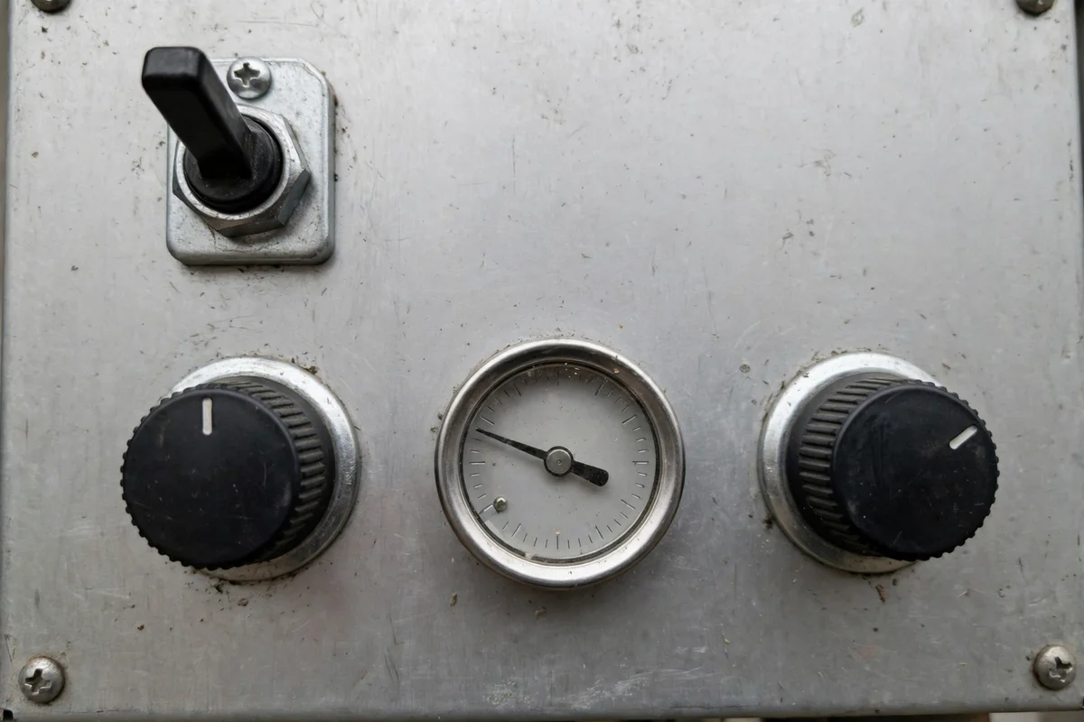 A boiler control panel with a power switch and indicator lights
